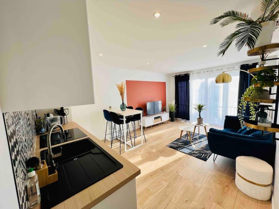 une cuisine et un salon avec un canapé et une table dans l'établissement Caen : Cocon moderne et chaleureux à 5mn du Centre, à Caen