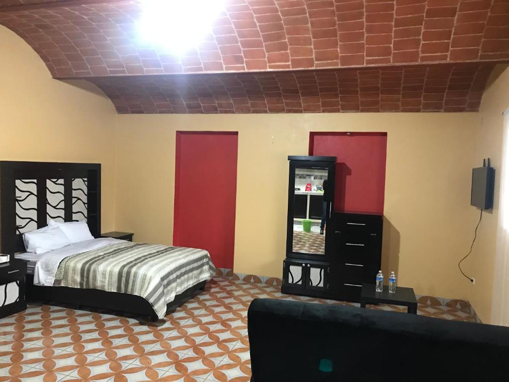 1 dormitorio con 1 cama, vestidor y TV en ALOJAMIENTO CAMPESTRE, en Ciudad de México