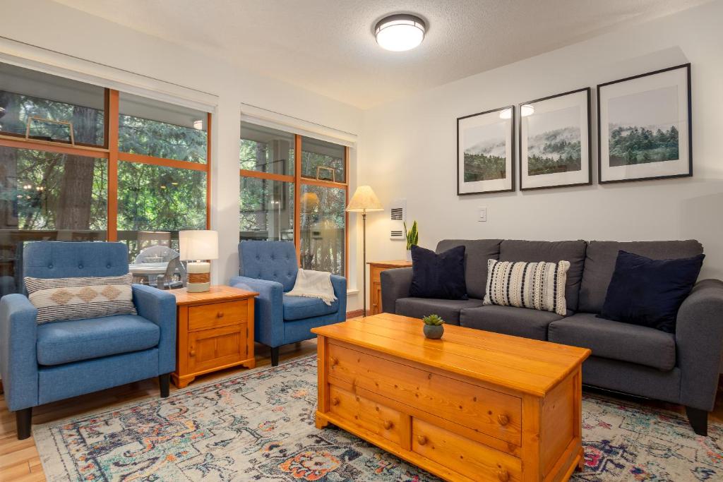 a living room with a couch and two chairs and a table at Steps From The Village with Pool and Hot Tub by Harmony Whistler in Whistler