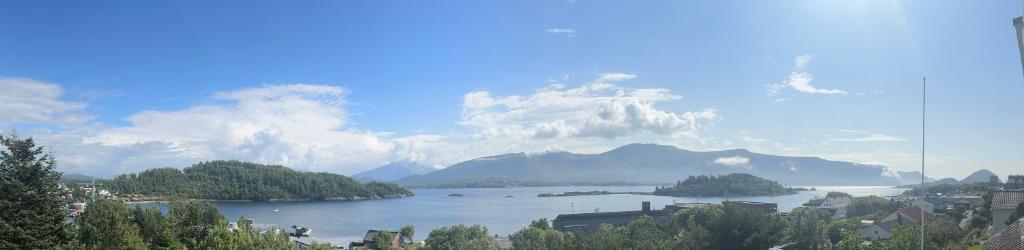 uma vista para um lago com montanhas ao fundo em Nørvegata 64 em Ålesund