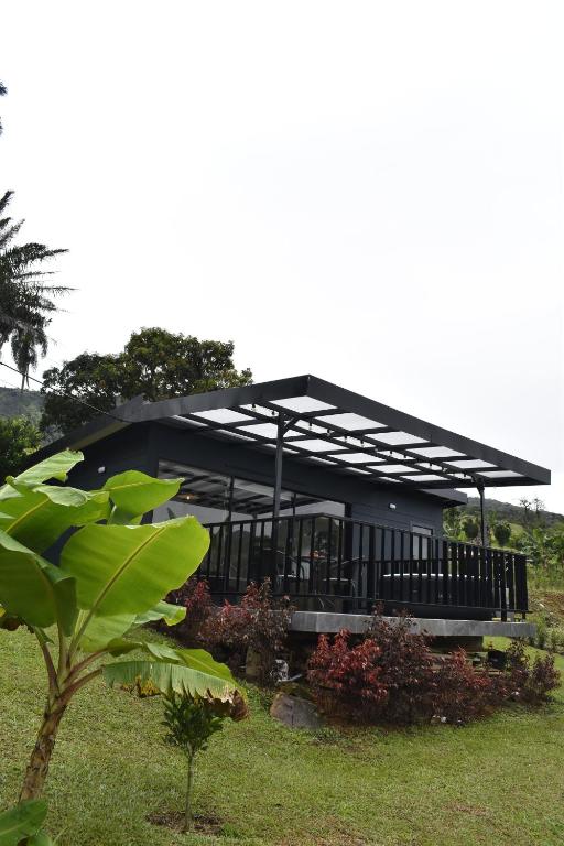 un edificio con una cubierta negra en la parte superior de un campo en Glamping La Montañita, en Medellín