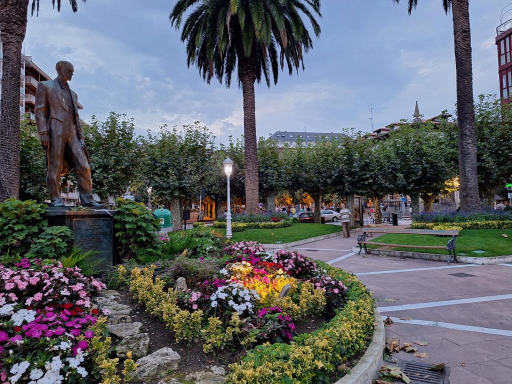 una estatua de un hombre en un parque con flores en Apartamento en Castro Urdiales centrico comodo y bien ubicado, en Castro Urdiales