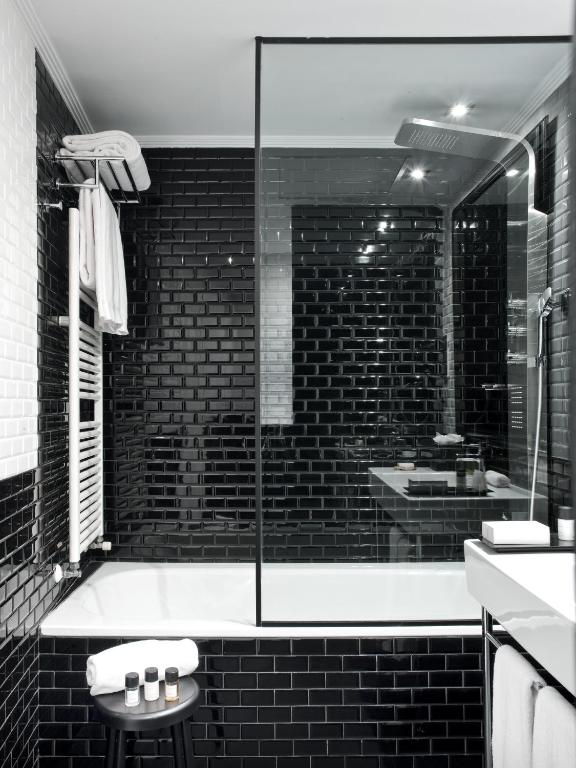a black and white bathroom with a tub and a sink at The Principal Madrid, Small Luxury Hotels in Madrid