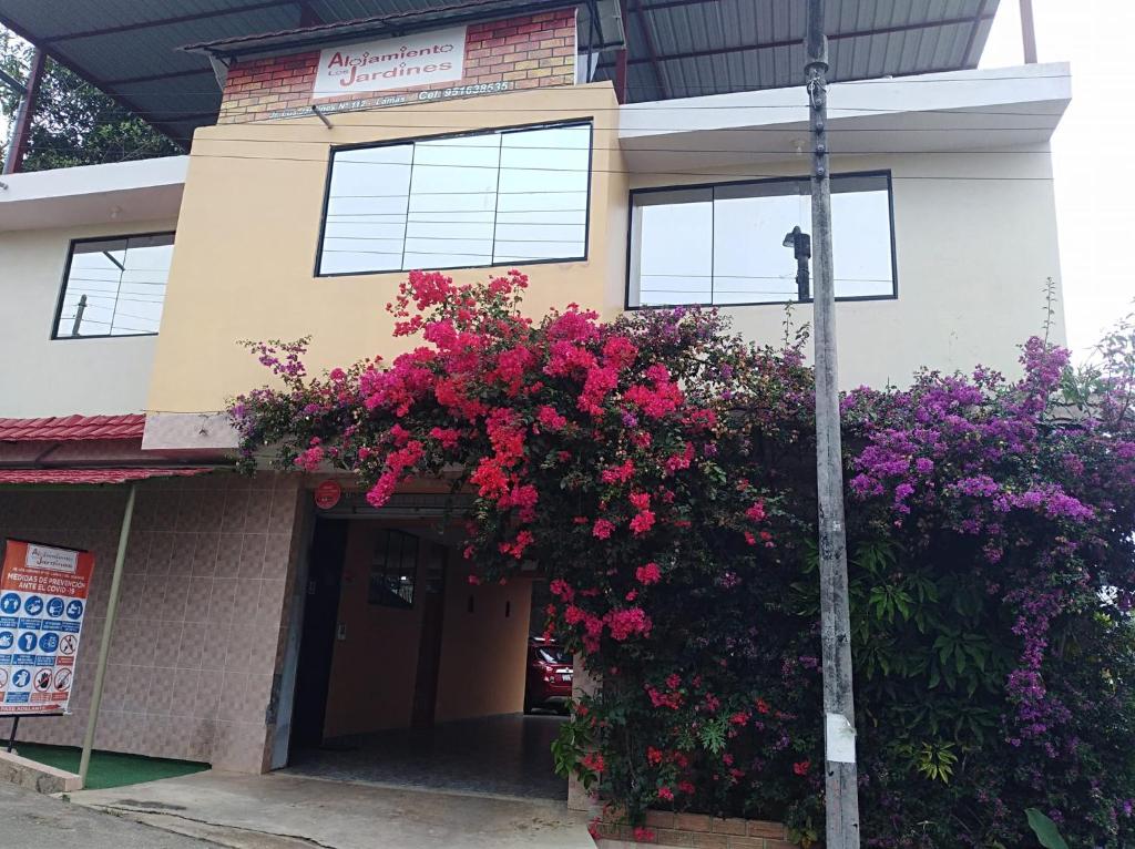 a building with flowers on the side of it at Alojamiento Los Jardines in Lamas