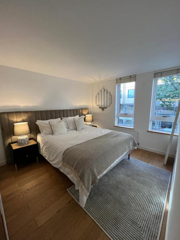 Heart of Covent Garden central apartment - 2 bed في لندن: غرفة نوم بسرير كبير ونوافذ
