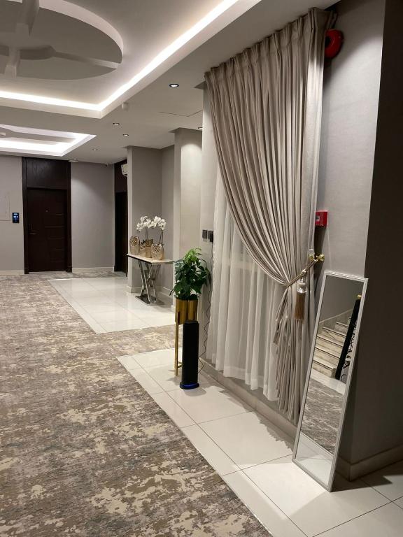 a room with a curtain and a door with a plant at شقق البندقية للشقق المخدومة Albundaqia serviced apartments in Riyadh