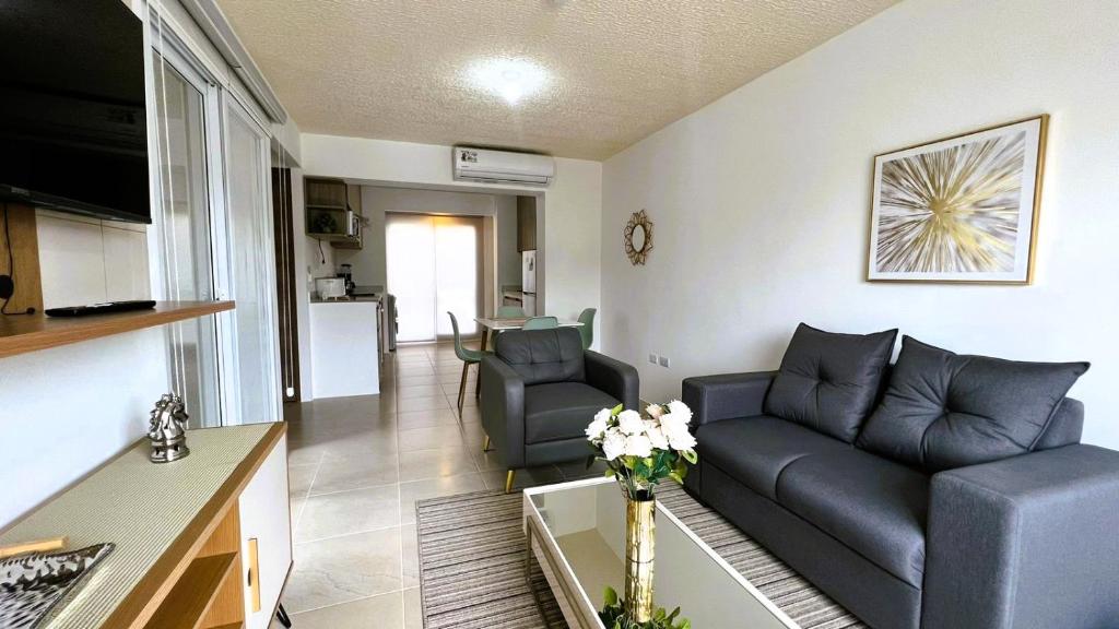 uma sala de estar com um sofá e uma mesa em Acogedor departamento en La Aurora 