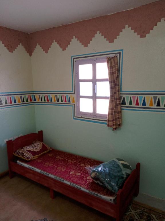 a small bedroom with a bed and a window at Hostel Yahdih Dakhla in Dakhla