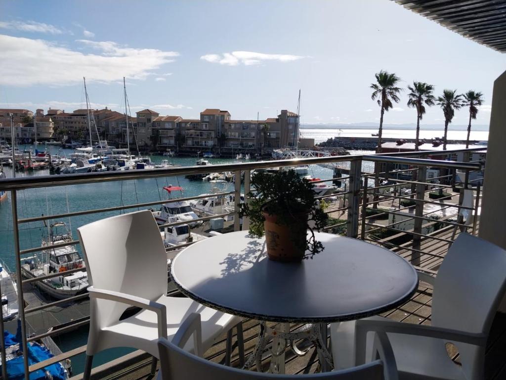 a table and chairs on a balcony with a marina at Ships Bell 17B in St Francis Bay