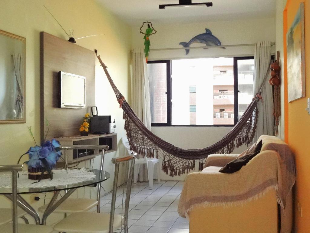 una sala de estar con una hamaca colgada de una ventana en Apartamento Ametista 2 + Bykes, en Maceió