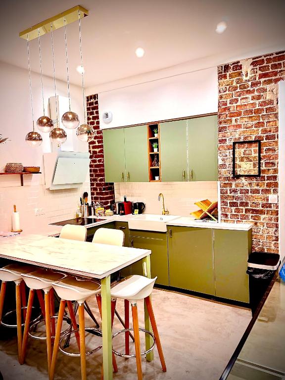 une cuisine avec une table et quelques armoires vertes dans l'établissement Appartement élégant - 2 chambres - 2 salles de bain, à Paris