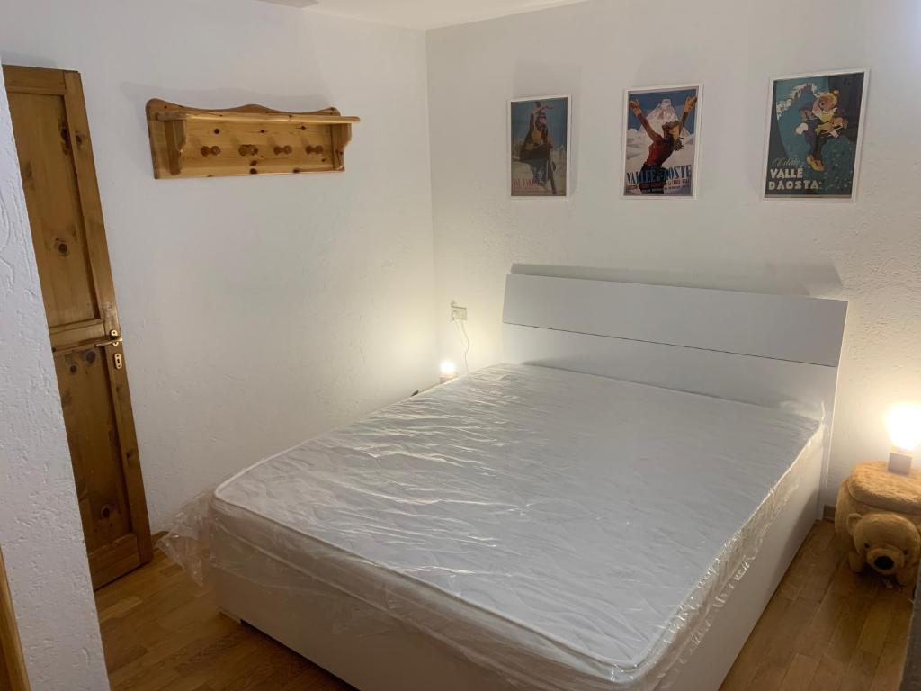 a bed in a room with two lights and two pictures at PI.GI.'s apartment in Pré-Saint-Didier