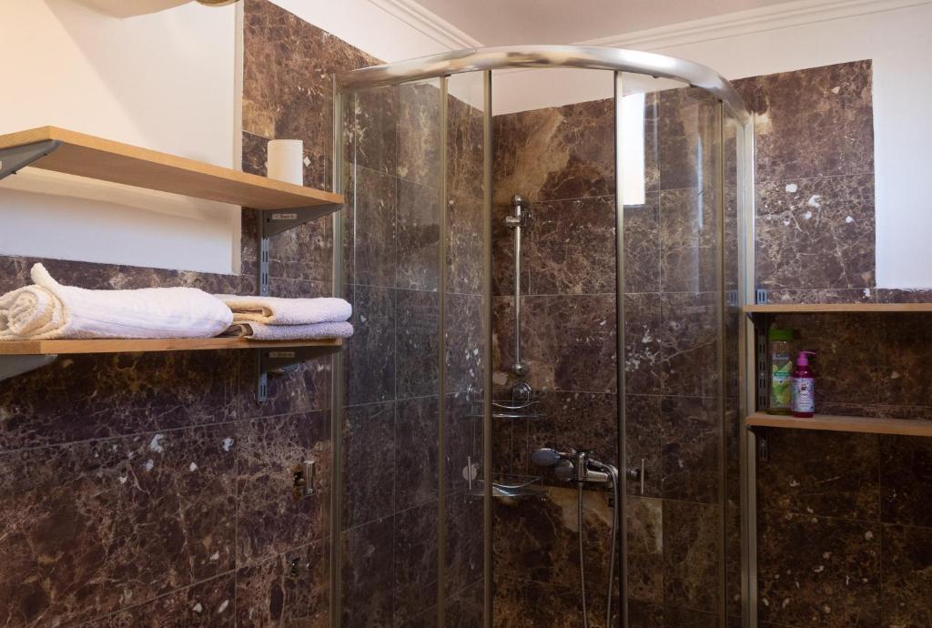 La salle de bains est pourvue d'une douche avec une porte en verre. dans l'établissement Boho Old Town Mostar, à Mostar