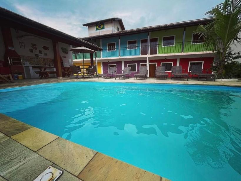 una grande piscina blu di fronte a un edificio di Recanto da Gabi a Ubatuba