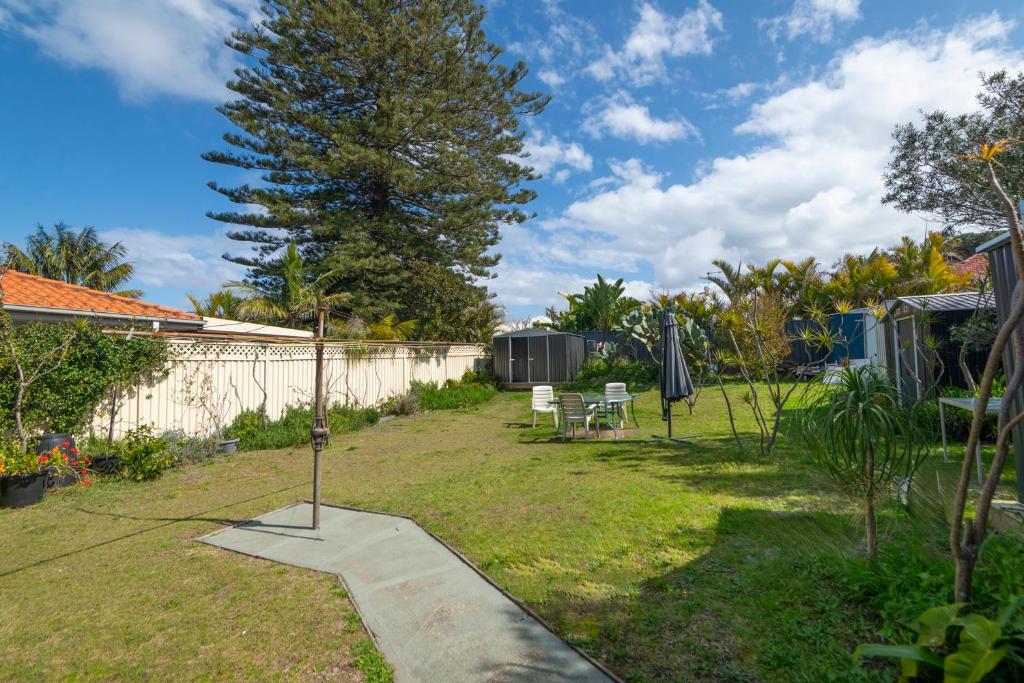 a garden with a sidewalk and a tree and a fence at Kurranulla Sapphire - U2 in Cronulla