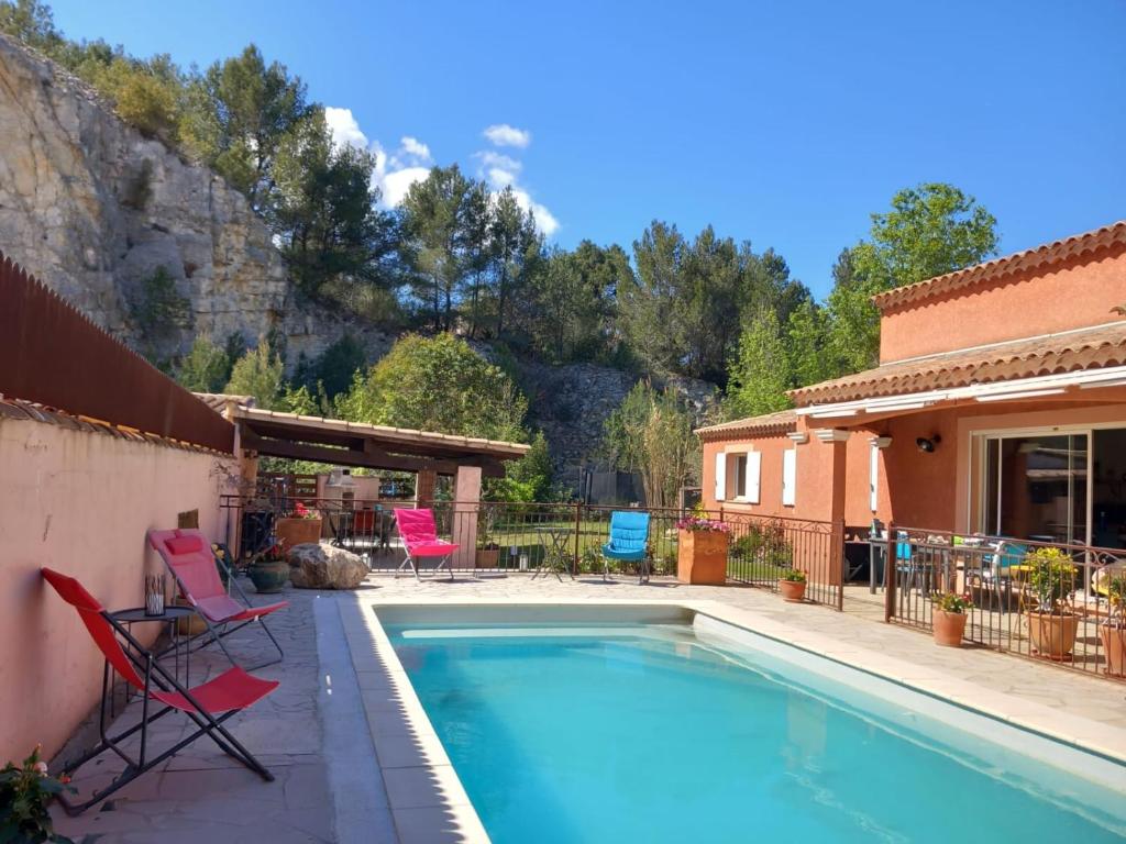 uma piscina com cadeiras e uma casa em Chambre(s) d'hôte chez Mam's em Beaucaire