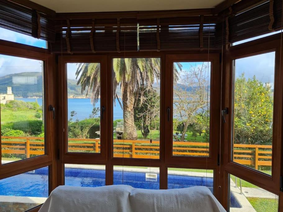 een slaapkamer met uitzicht op het water door de ramen bij El Mirador del Mar in O Vicedo