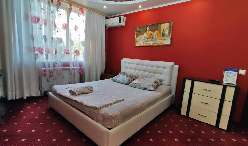 1 dormitorio con cama y pared roja en Apartment on Sportivnaya en Bender