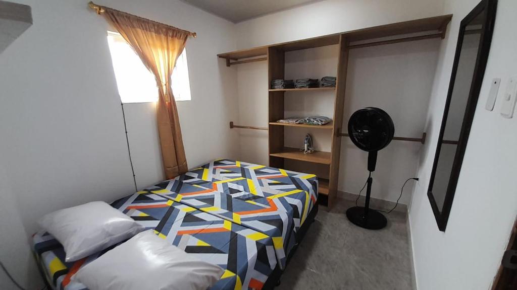 a bedroom with a bed and a fan in it at Apto Hogar Dulce Hogar ARBOLETES in Arboletes
