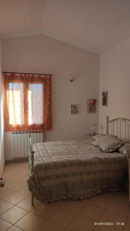 Schlafzimmer mit einem Bett und einem Fenster in der Unterkunft Soleluna in Levanto