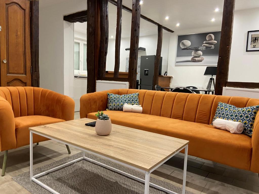 a living room with a couch and a coffee table at La galerie, proche aéroport in Tillé