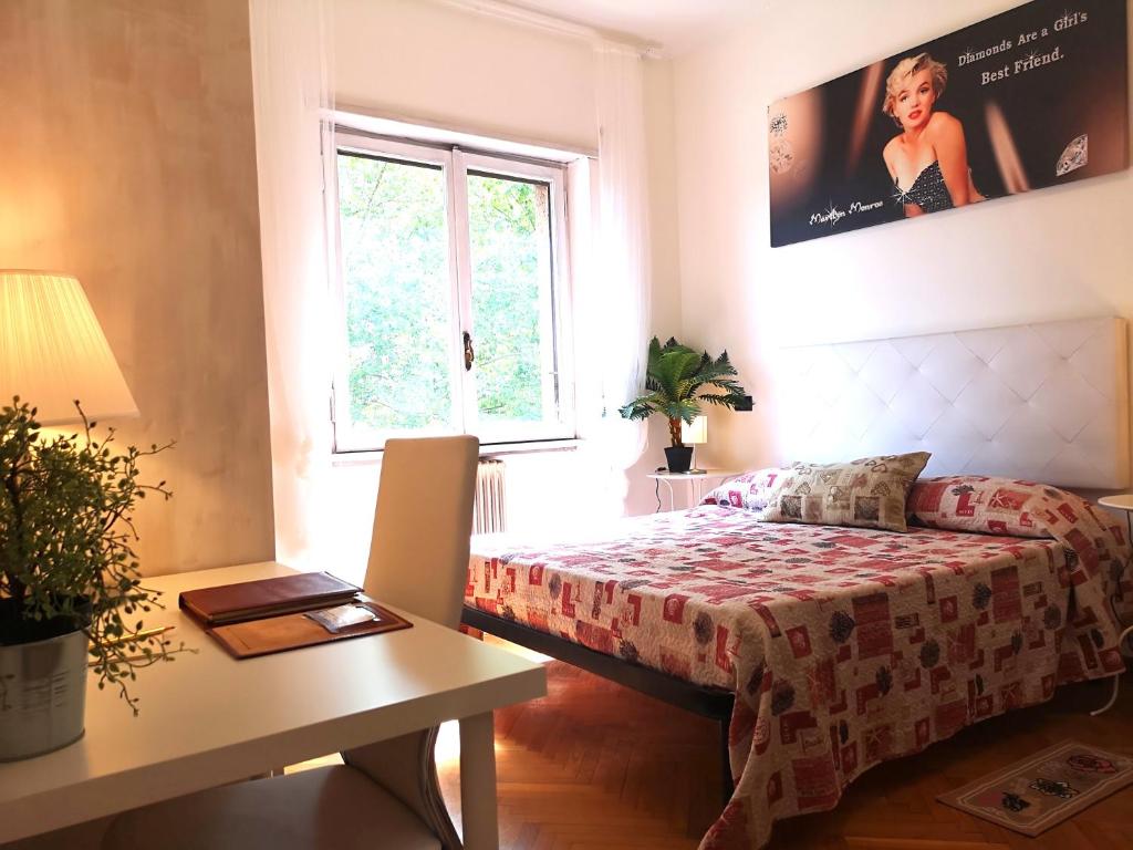 sypialnia z łóżkiem, stołem i oknem w obiekcie DREAMS APARTMENT w Rzymie