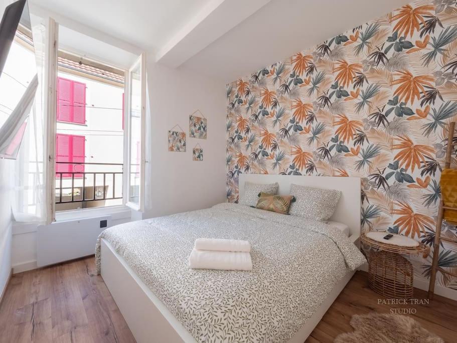 a bedroom with a bed with a floral wall at Logement pour 8 personnes près de Disney & Paris in Chanteloup-en-Brie