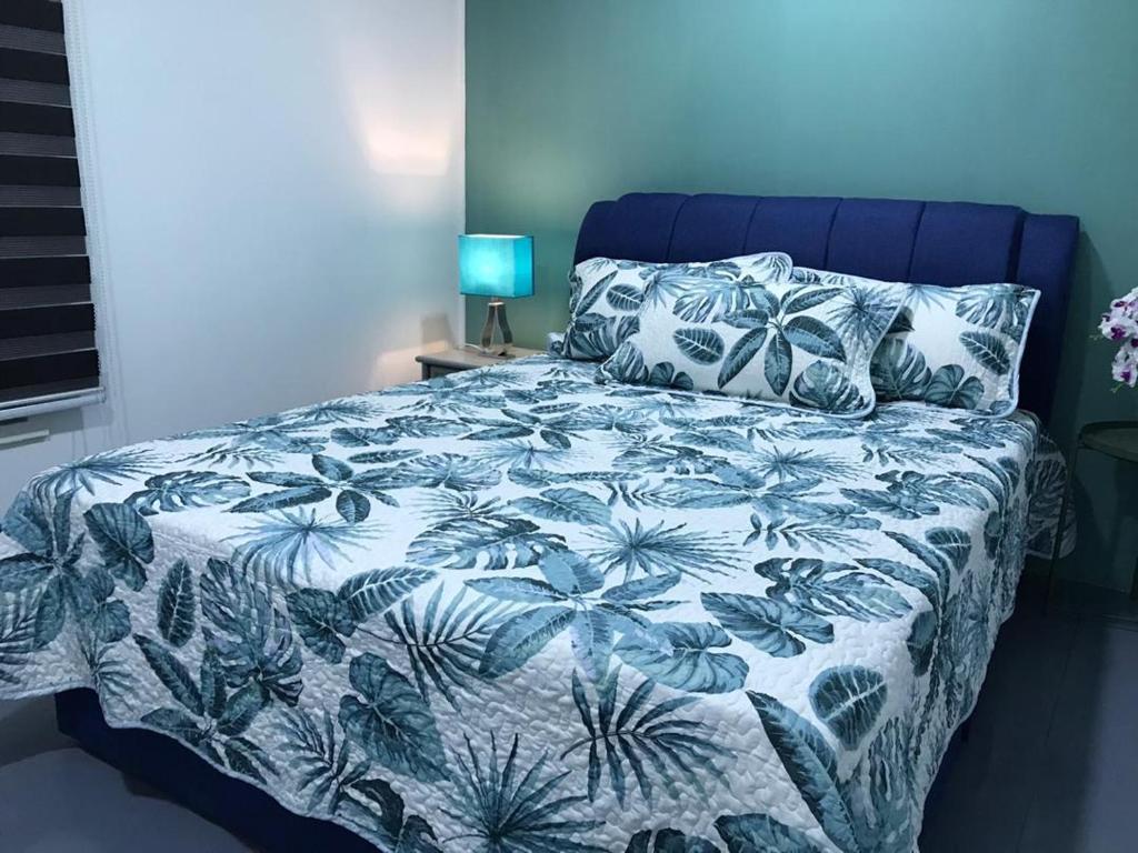 een slaapkamer met een bed met een blauw en wit dekbed bij lot 1217 large private villa with pool A’Famosa golf resort melayu in Kampong Alor Gajah