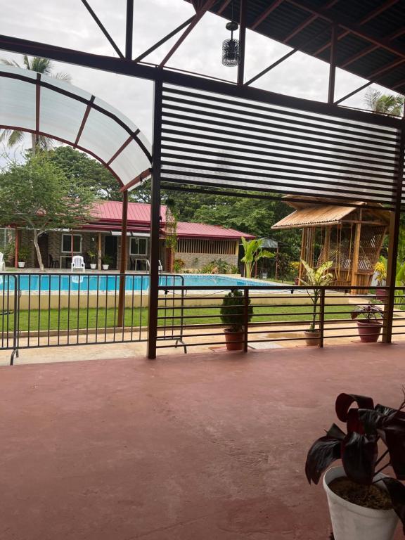a pavilion with a swimming pool and a fence at Elena Guest House & Resort in Medellin