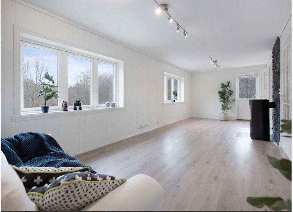 an empty living room with a couch and windows at 5-Bedroom Apartment in Åsane, Bergen in Bergen
