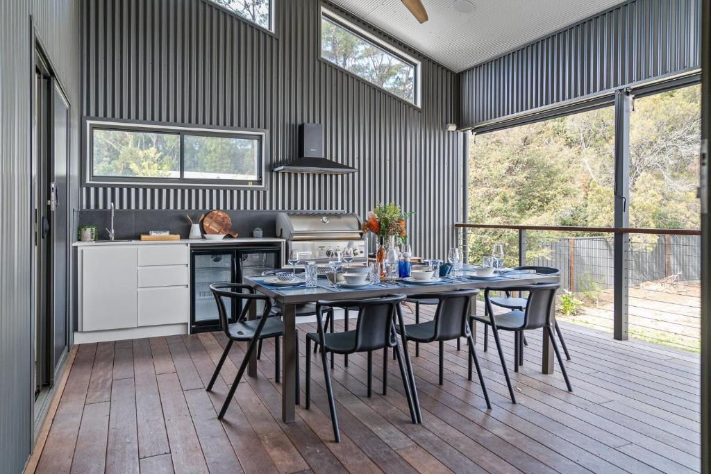 a dining room with a table and chairs in a kitchen at Coastal Retreat in Kioloa