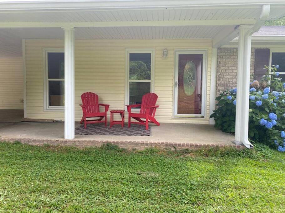 - deux chaises rouges et une table sur une terrasse couverte dans l'établissement Ranch - Allatoona Lake, LakePoint Sporting, Hiking, à Acworth