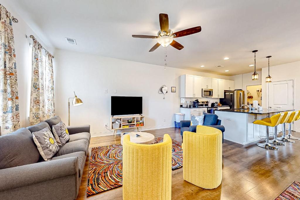 a living room with a couch and chairs and a kitchen at Daisy Place in Charleston
