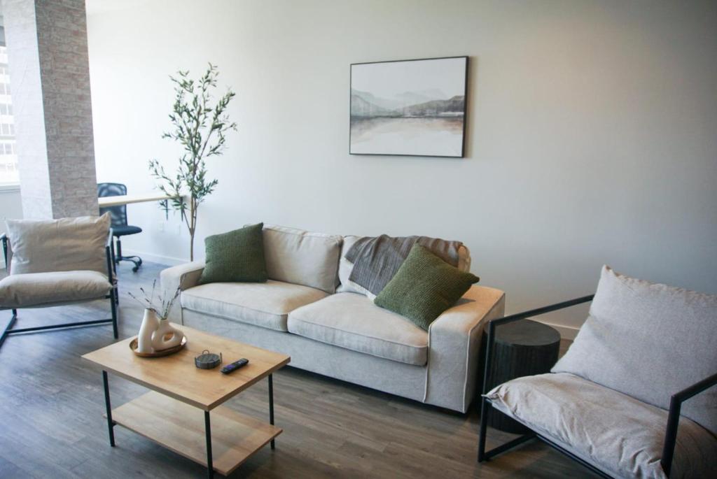 Entire High-Rise Apartment - 2BD في باتون روج: غرفة معيشة مع أريكة وكرسيين وطاولة