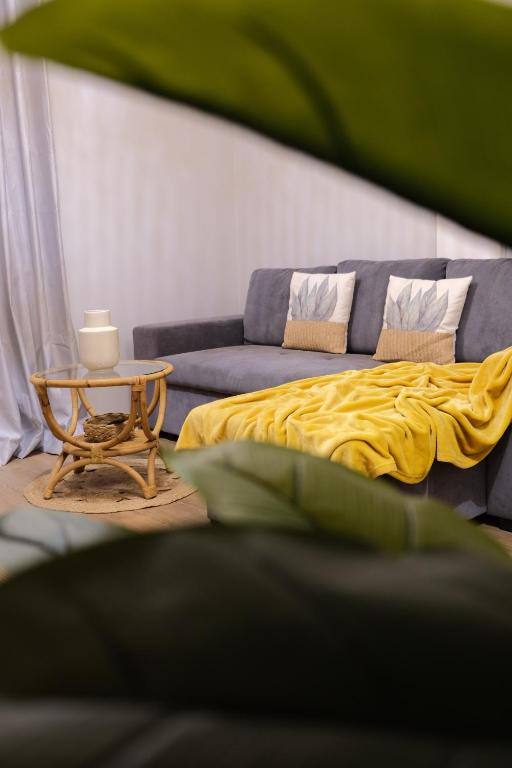 a bed with a yellow blanket and a table at Résidence Terre et Passion in Ducos