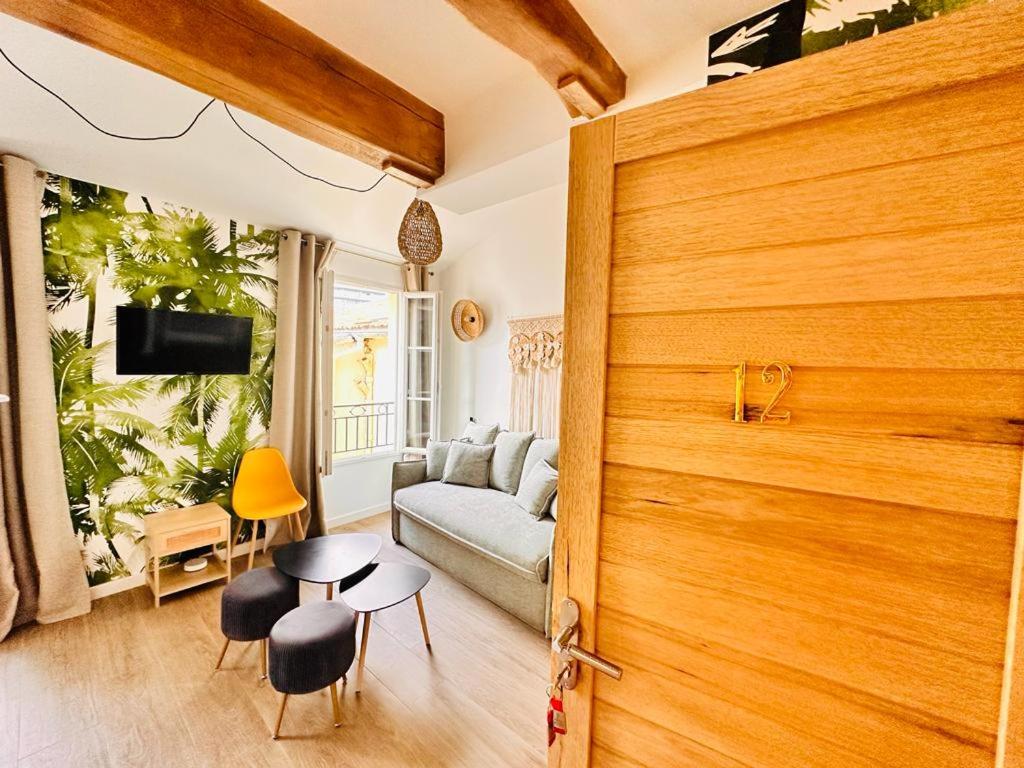 un salon avec un canapé et une table dans l'établissement Les Appartements de Nana 12 - Studio hypercentre, Rue Meynadier, Palais & Plage, clim, wifi, à Cannes
