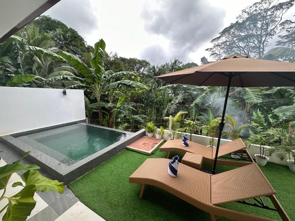 a patio with an umbrella and chairs and a pool at Rvilla El Nido in El Nido
