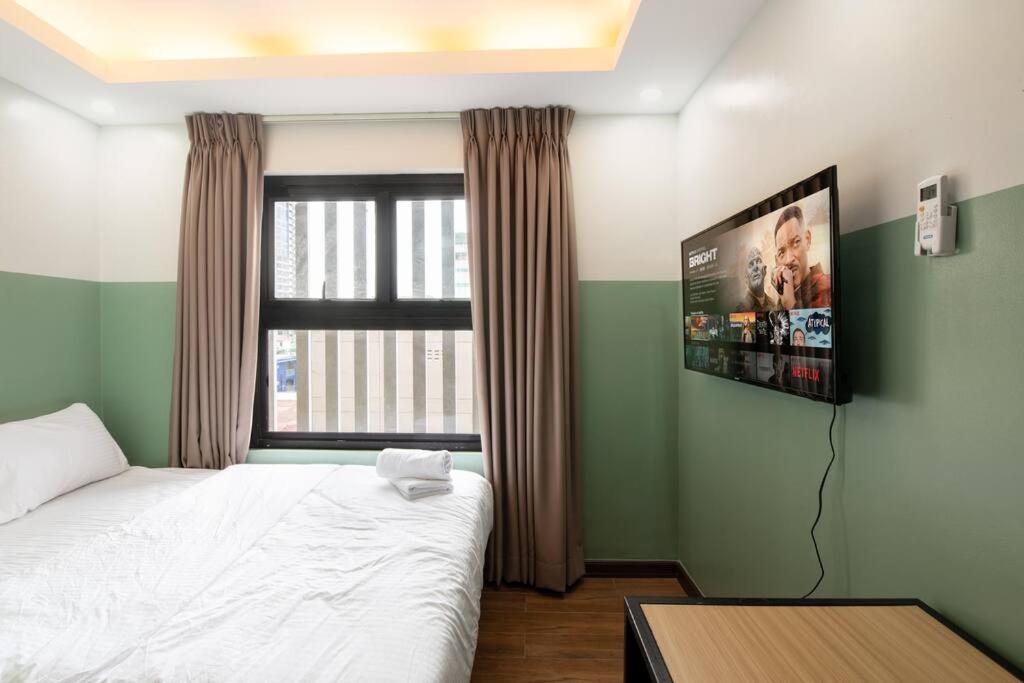 een slaapkamer met een bed en een tv aan de muur bij St. Marvin Studio Makati M308 in Manilla