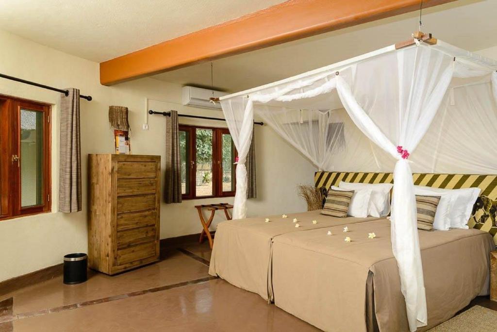 a bedroom with a bed with a canopy at Montebelo Gorongosa Lodge & Safari in Chitengo
