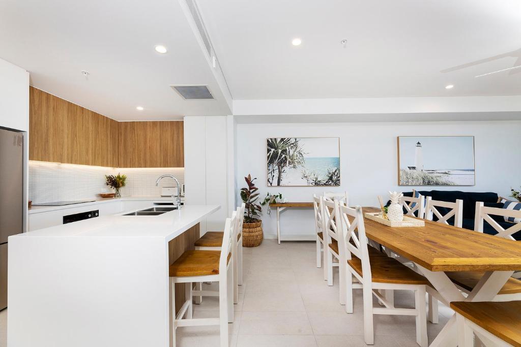 a kitchen and dining room with a wooden table at Solaris 606 in Forster