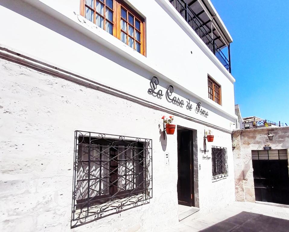 a white building with a gate on the side of it at Hotel La Casa de Irma in Arequipa