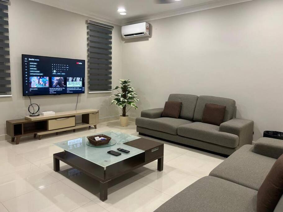 a living room with a couch and a tv at Spacious Home @ Kuching City Ctr in Kuching