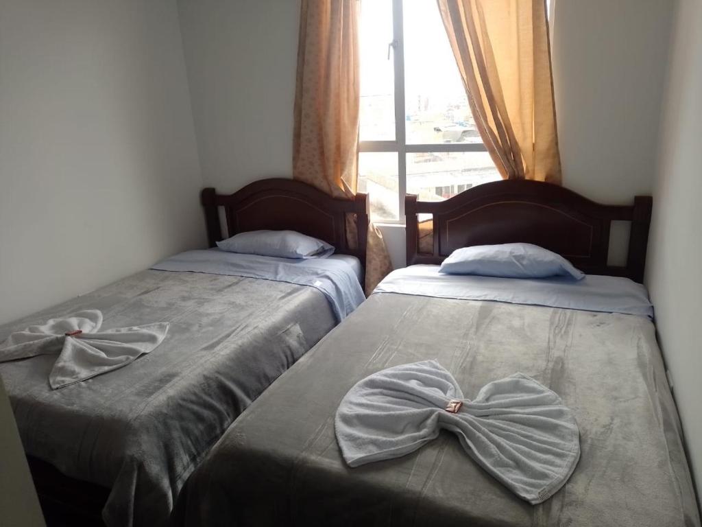 two beds with bows on them in a room at Apartamento en ipiales nariño, cerca a la frontera con ecuador in Ipiales