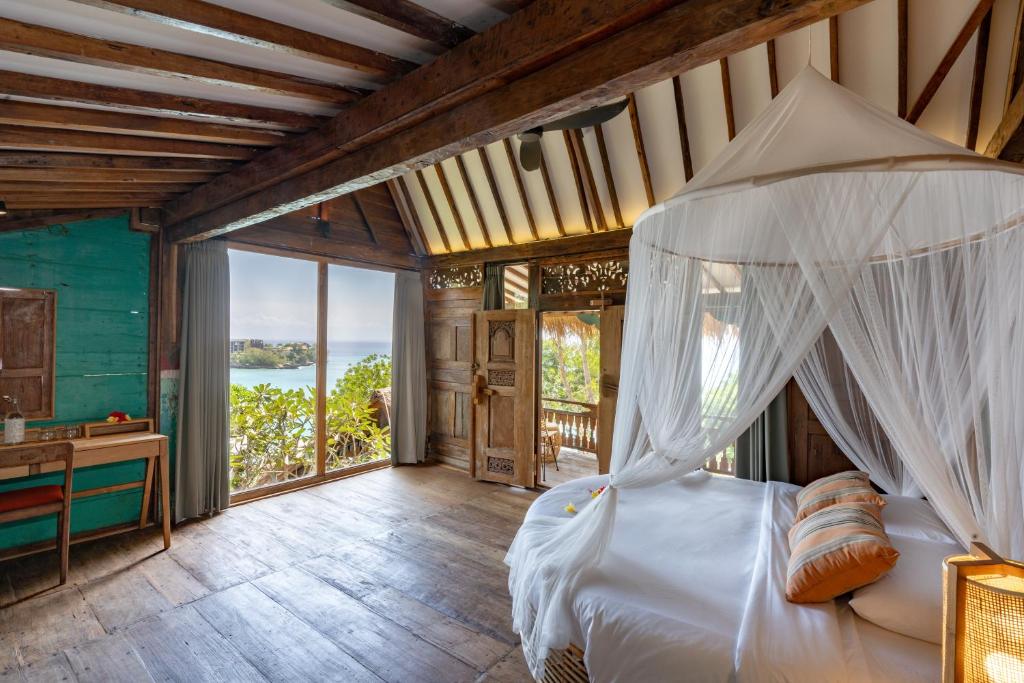 a bedroom with a bed with a canopy at Morin Resort in Nusa Lembongan