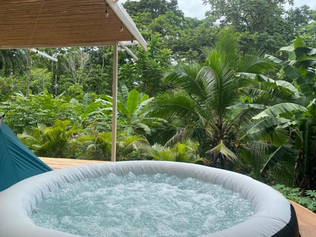 a large bath tub sitting on top of a patio at Serenity Glamping in Puerto Viejo