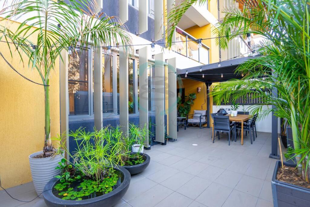 a patio with plants and a table in a building at Zen Seaside 1BR Waterfront Apt in Darwin