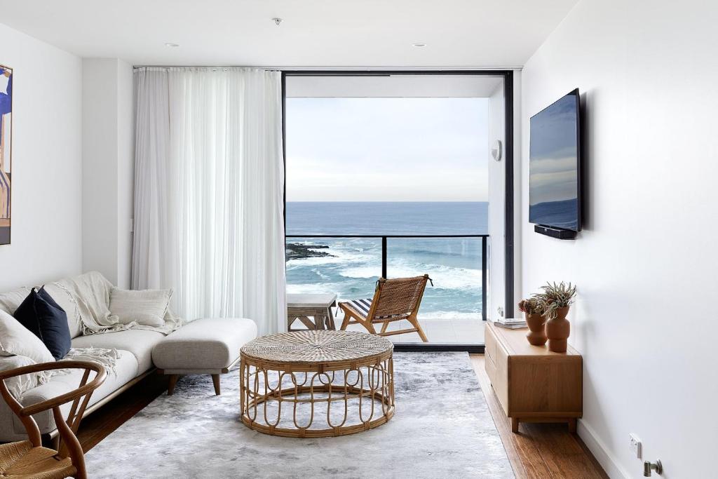 a living room with a couch and a view of the ocean at Surf Mist in Newcastle