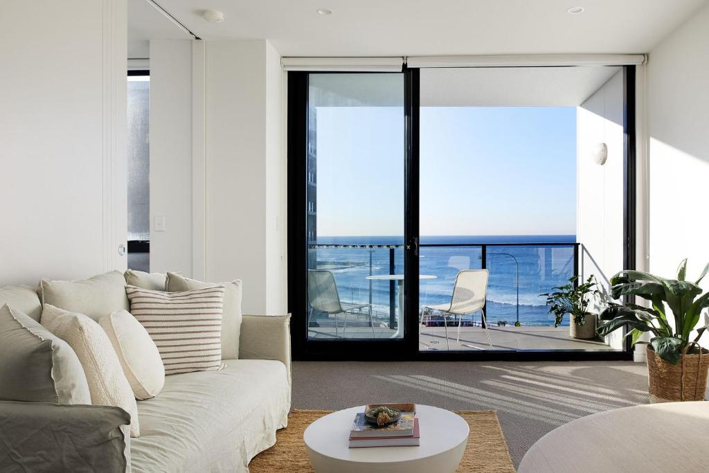 a living room with a couch and a view of the ocean at The Cove in Newcastle