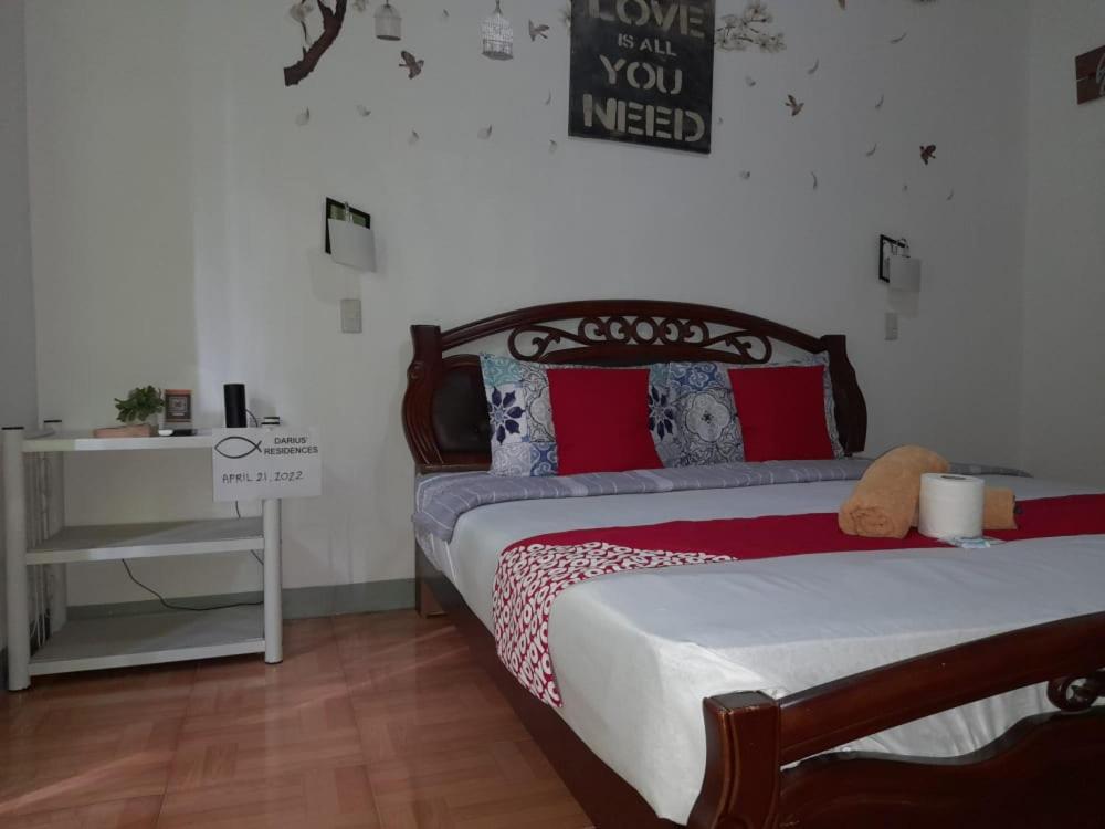 YOO Darius' Residences في موالبوال: غرفة نوم مع سرير وإشارة تقرأ الحب هل تحتاج