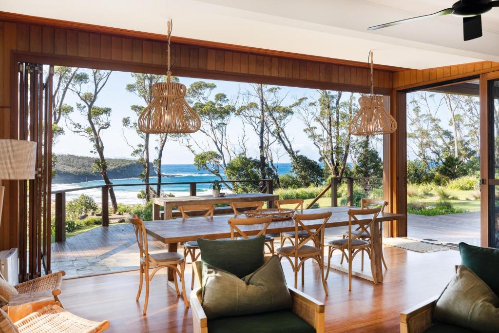 an open living room with a table and chairs at Pebbly Beach Escape in East Lynne
